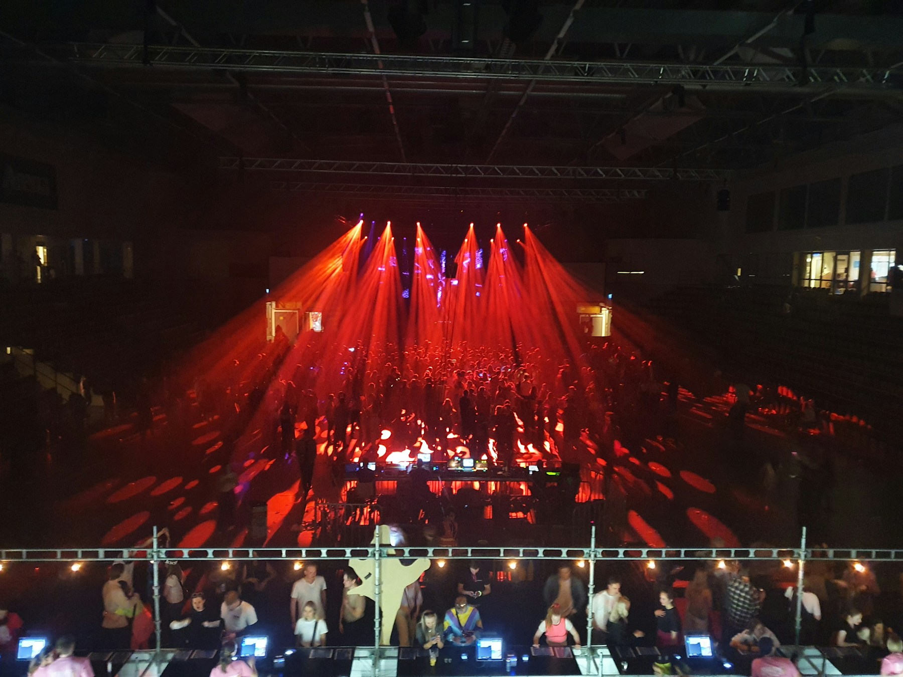 Scène électronique et foule sous des lumières rouges